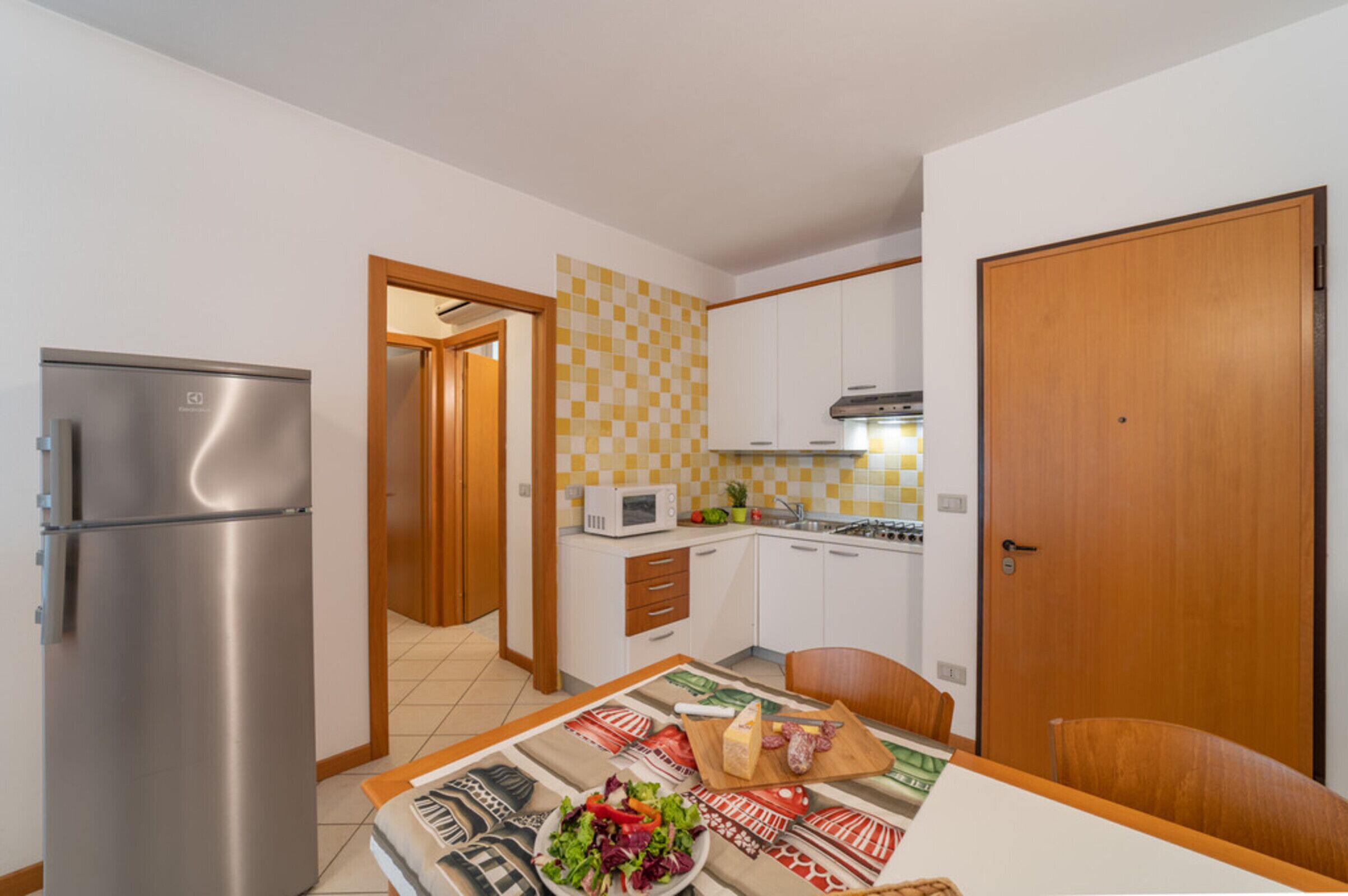 A compact kitchen with a refrigerator, microwave, and stove.