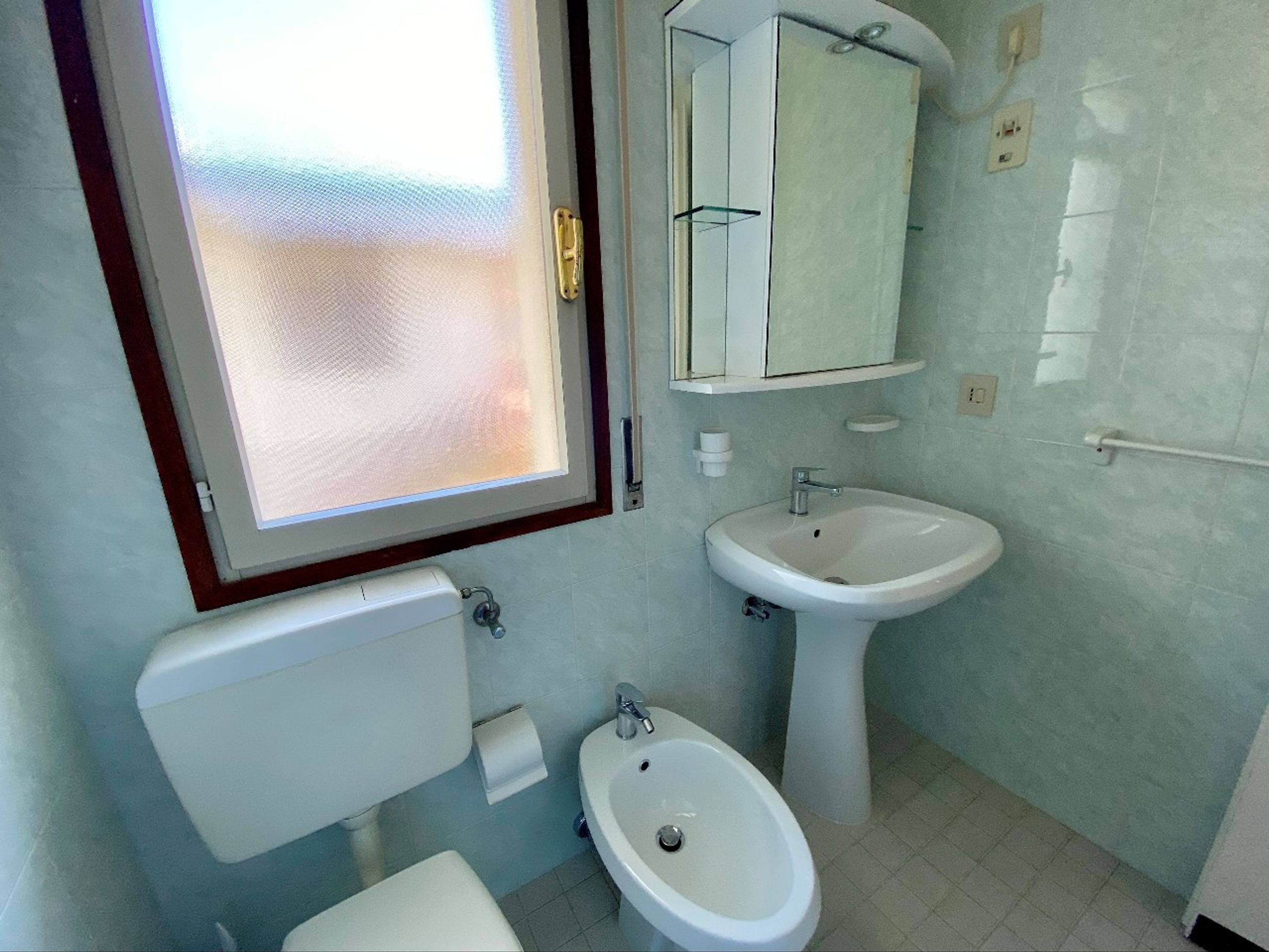 Ein Badezimmer mit Toilette, Bidet und Waschbecken.
