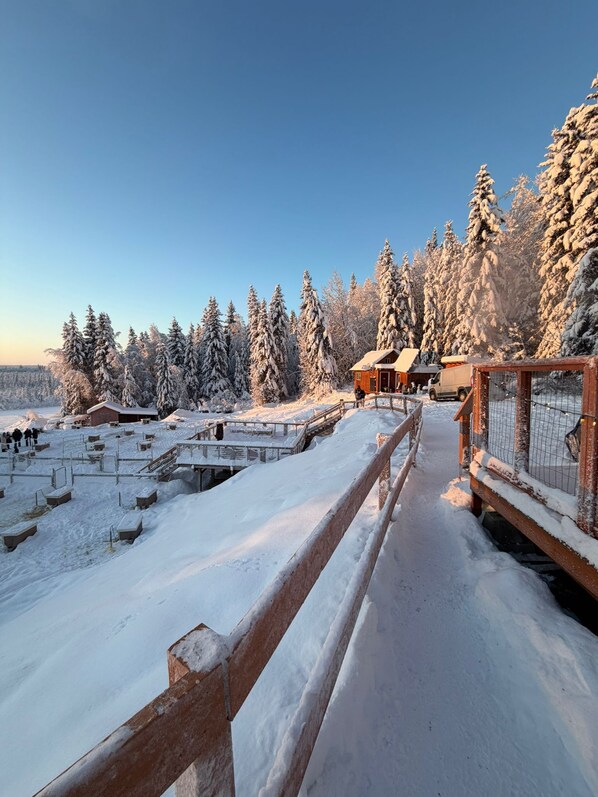 A snow-covered landscape with wooden structures and a wooden fence. - Quiet North Pole Stay near Santa and FAI with Arctic Spa (North Pole)