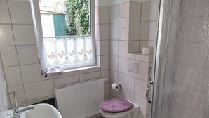 Un bagno piccolo con il water, un lavandino e una finestra.