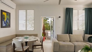 A modern living room with a round dining table, beige sofa, and a ceiling fan. - Ocean Park 3BDR+2BA Hot Tub Terrace @Riviera Villa (San Juan)