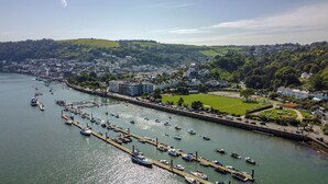 A coastal town with a marina, residential buildings, and green hills in the background. - Elegant Couples' Escape in Dartmouth (Dartmouth)