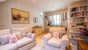 A living room with a sofa set, a coffee table, and a bookshelf. - Elegant Couples' Escape in Dartmouth (Dartmouth)