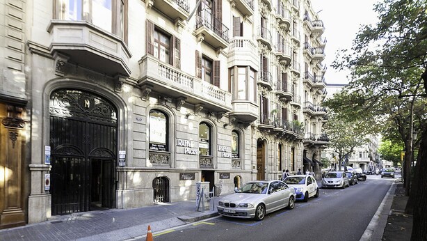 A row of classic European-style buildings with ornate facades and large windows. - RAMBLA CATALUNYA SKY (Barcelona)