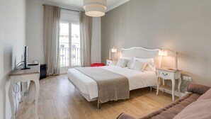 A hotel room with a large bed, bedside tables with lamps, a desk with a computer, and a window with curtains. - RAMBLA CATALUNYA SKY (Barcelona)