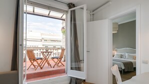 A room with a balcony, a bed, and a white door. - RAMBLA CATALUNYA SKY (Barcelona)