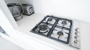 A kitchen with a gas stove, a toaster, and a coffee maker.