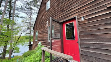Sit and enjoy the serene surroundings from the wooden bench outside this cozy cabin.