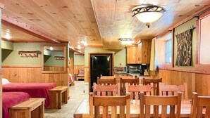 A wooden interior with a dining area, benches, and a kitchen. - Club 51 (Mercer)