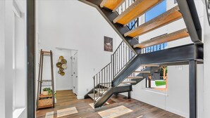 Ein modernes Interieur mit einer Treppe, Holzböden und Blick ins Freie.