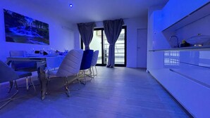 A modern kitchen with a dining area, a large window, and a painting on the wall. - One Lux Stay Near Antwerp Central Grande Deluxe 3 Bedroom Suite (Antwerp)