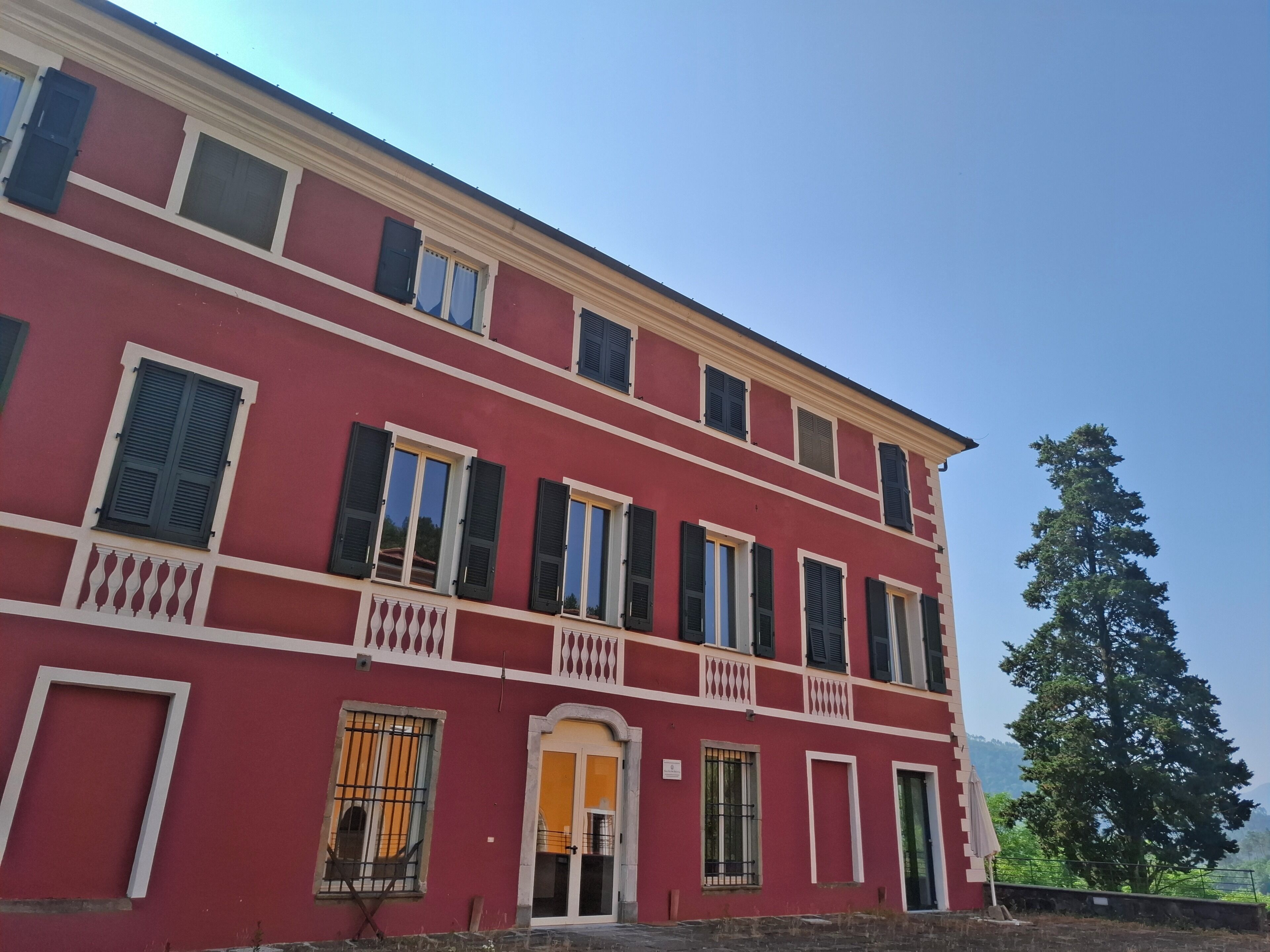 Um edifício vermelho com várias janelas e varandas.