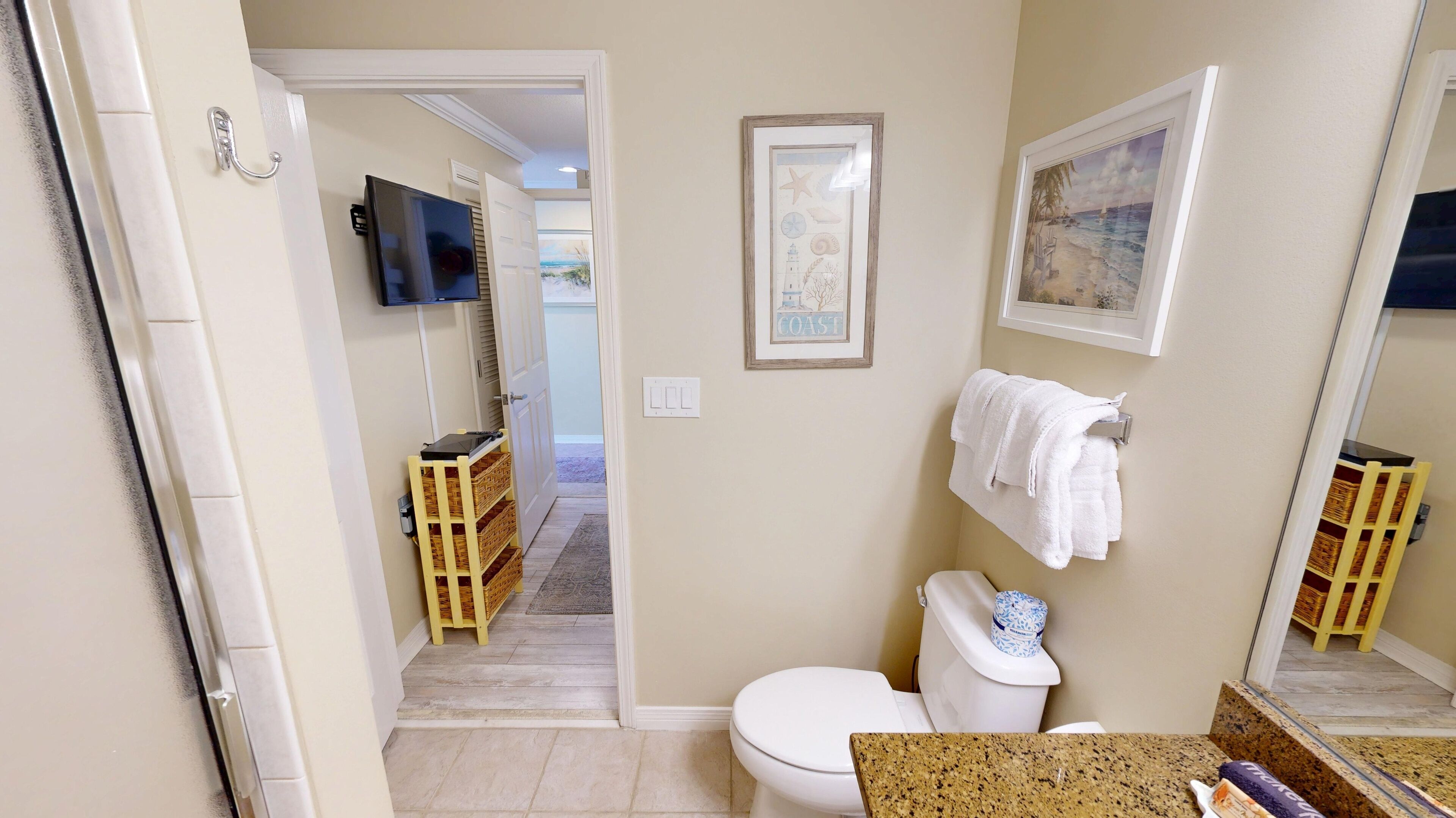 Une salle de bain avec des toilettes, un lavabo et un tableau encadré au mur.