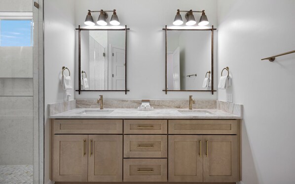 A bathroom with two sinks, a mirror above each, and a towel rack on the wall. - Elegant 5BR, Pool + Spa, Golf Cart & More! (Santa Rosa Beach)