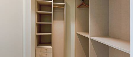 A walk-in closet with open shelves, drawers, and hanging space.