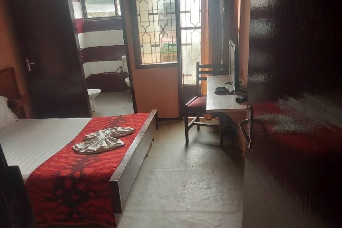 A room with a bed, a desk, and a window.