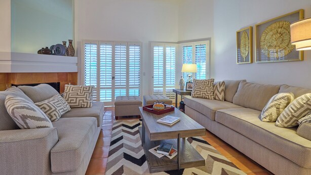 A living room with two sofas, a coffee table, and a fireplace.
