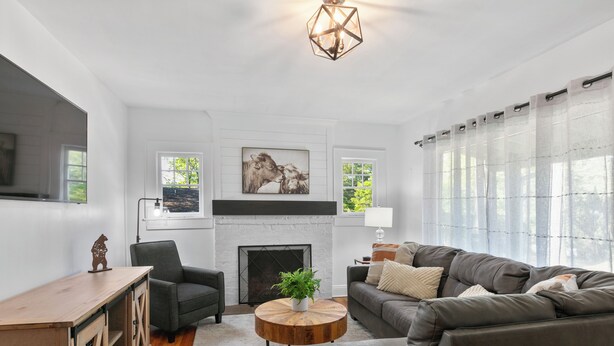 Una sala de estar con chimenea, un sofá, una mesa de centro y un televisor.