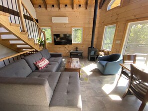 Un interior de madera con un sofá, un sillón y un televisor.