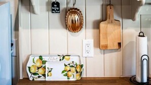 A kitchen shelf with wicker baskets, a ceramic pitcher, and a decorative plate.