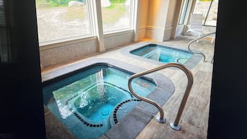A spa area with two hot tubs and a wooden floor.