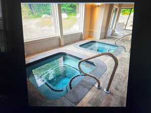 Ett spaområde med två bubbelpooler och ett trägolv.