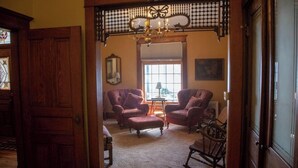 Una habitación con dos sillones, una mecedora y una pequeña mesa.