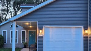 A residential house with a garage, a front door, and a mailbox.