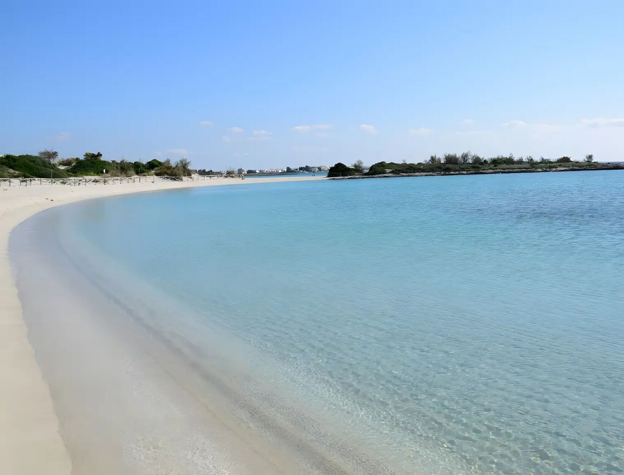On peut clairement voir une plage avec un rivage sablonneux et une eau calme.