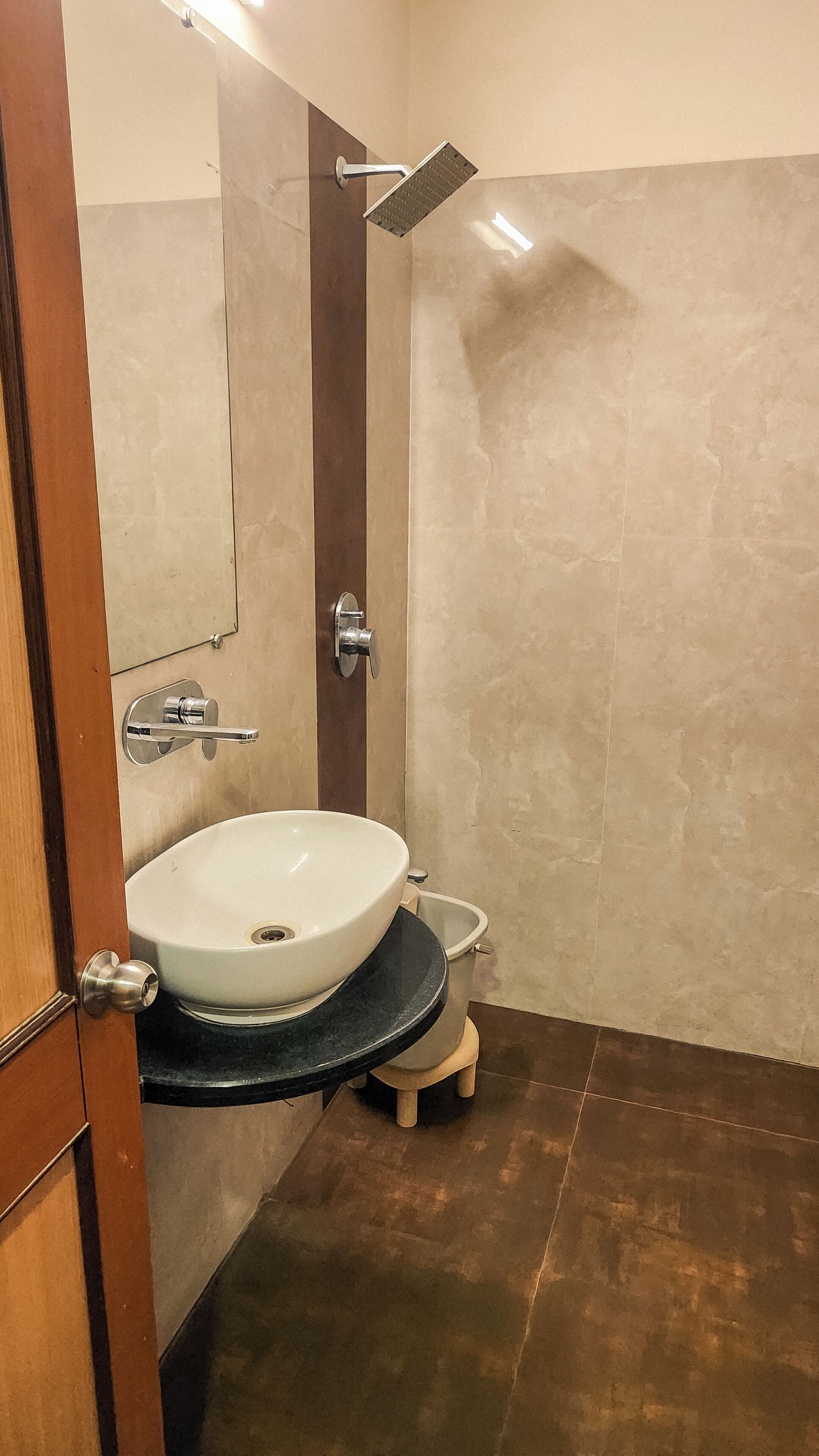 A bathroom with a white sink, a shower head, and a toilet.
