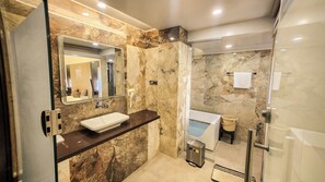 A modern bathroom with a marble vanity, a large mirror, a shower, and a towel rack.