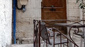 A building entrance with a wooden door, a staircase, and a metal railing. - Apartment downtown Forcalquier (Forcalquier)