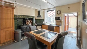 Une cuisine équipée d’une table à manger, de chaises, d’une cuisinière et d’un four à micro-ondes.