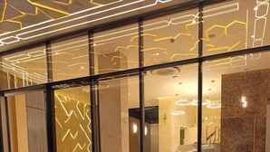 Ein Hotel Eingang mit modernem Design, mit einer Glasfassade und einem Schild, auf dem 
