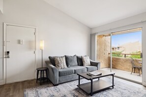 A modern living room with a grey sofa, a coffee table, and a floor lamp.