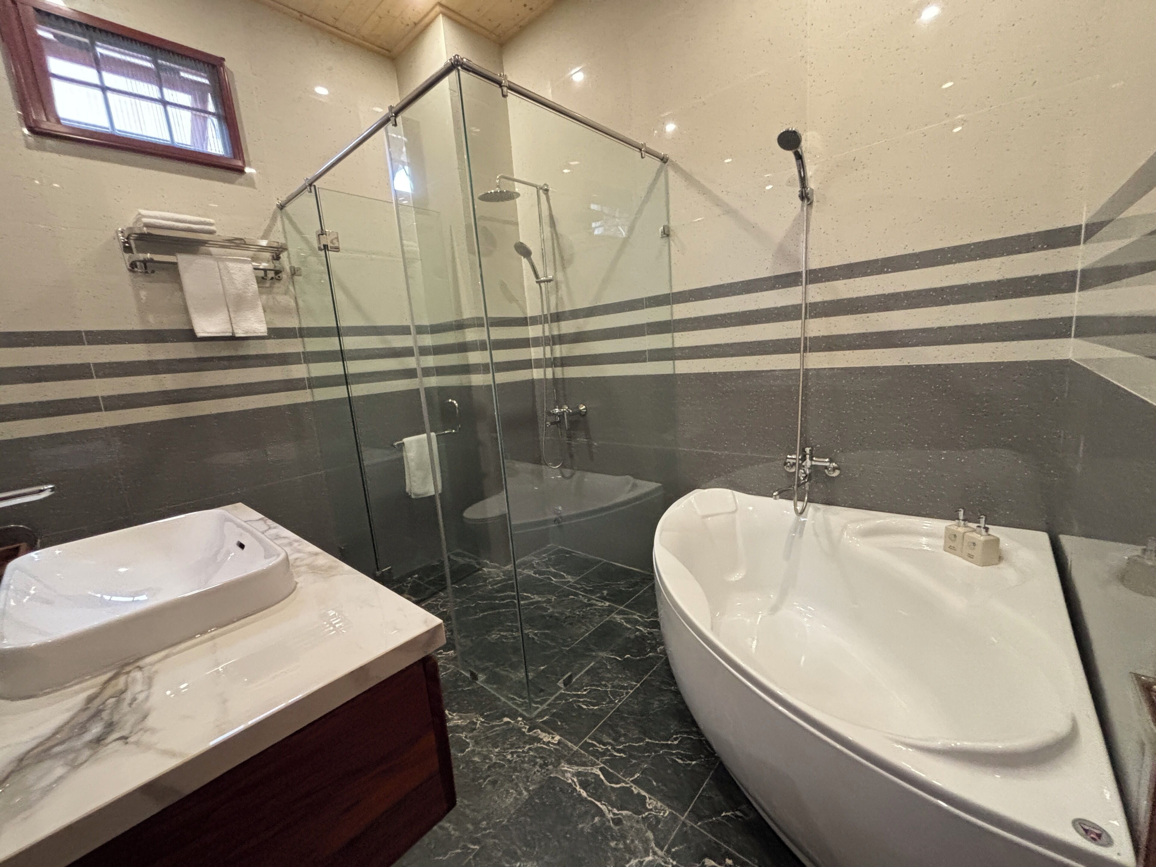 Une salle de bain avec une douche à parois de verre, une baignoire et un meuble-lavabo avec un évier.
