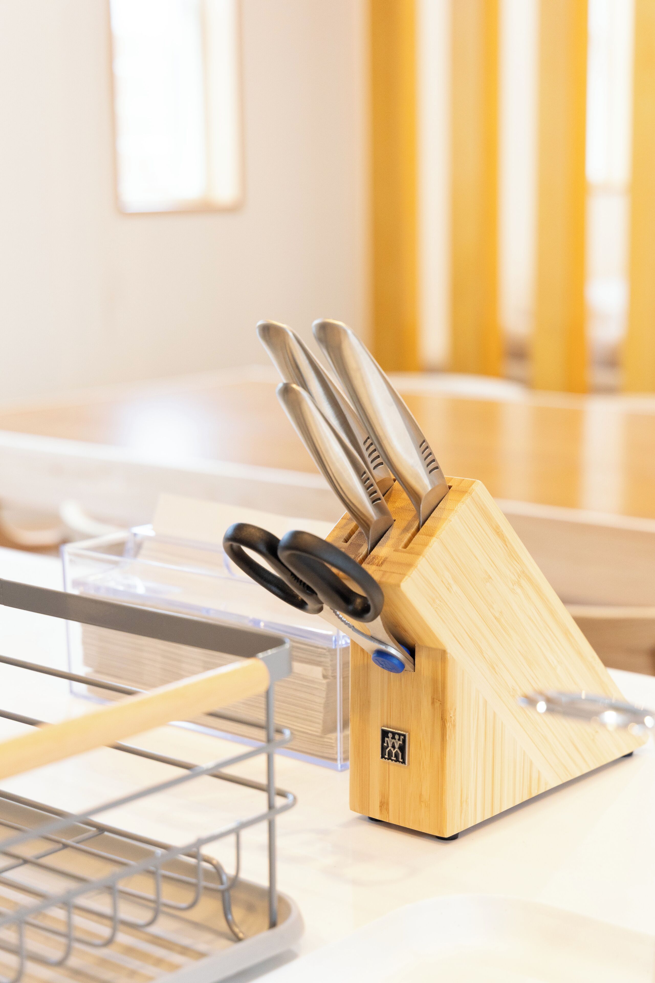 A kitchen area with a wooden knife block holding several knives.