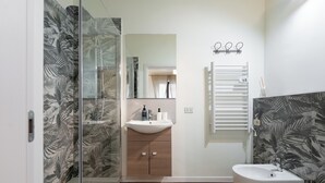 A modern bathroom with a glass shower enclosure, a wooden vanity, a white sink, and a toilet. - MusArt Yellow Room (Firenze)