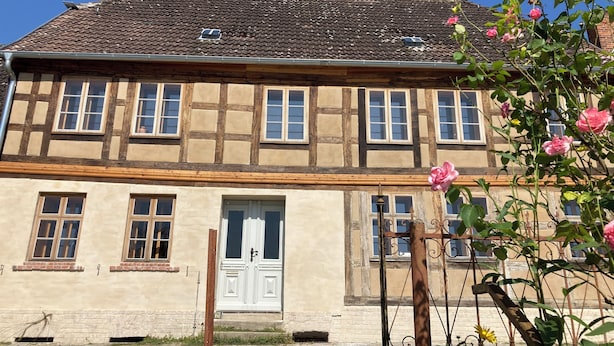 A traditional half-timbered house with a tiled roof, a central entrance, and a brick base. - Vacation apartment Fischerhaus Havelberg (Havelberg)