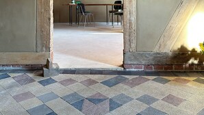 A room with a checkered floor, a wooden-framed doorway, and a table with chairs. - Vacation apartment Fischerhaus Havelberg (Havelberg)