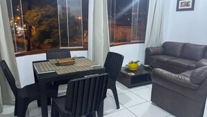 Ein Wohnzimmer mit Essbereich, einem braunen Ledersofa und einem Tisch mit Stühlen.