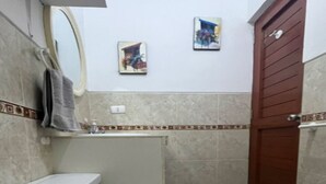 Ein kleines Badezimmer mit Toilette, Waschbecken und Duschbereich.