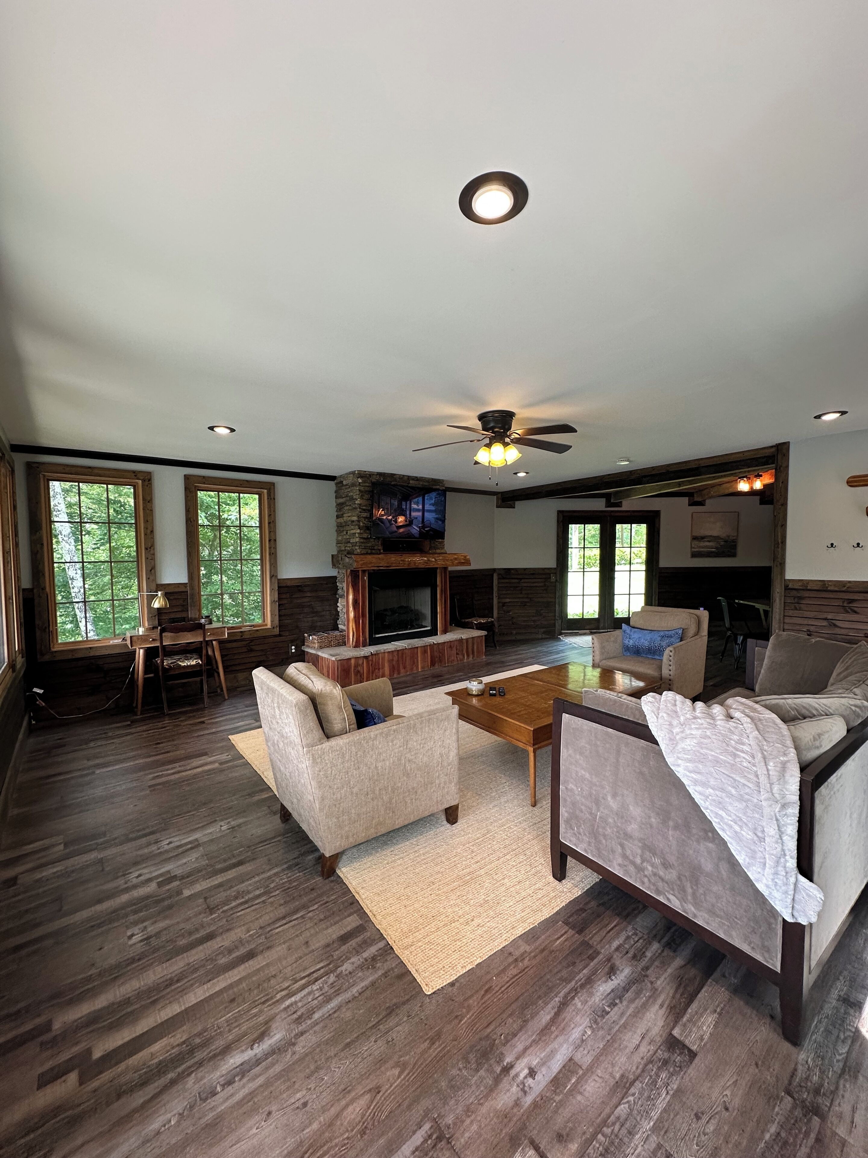 A spacious living room with a fireplace, comfortable seating, and a television.