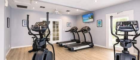 A home gym with treadmills, an elliptical, and a stationary bike.