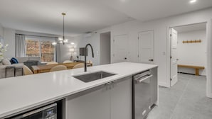 A modern kitchen with a central island, built-in appliances, and a dining area with a bench.
