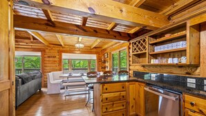 A cabin interior with a kitchen, dining area, and a sofa.