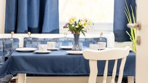 A dining table set with plates, cups, and a vase of flowers.