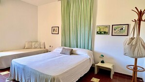 Une chambre d’hôtel avec un lit, une table de chevet, une lampe et une chaise.