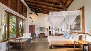A spacious room with a large bed, a wooden bench, and a desk with a lamp. - Mount Cinnamon - Exclusive Villa in Mirissa with WiFi, AC (Mirissa)
