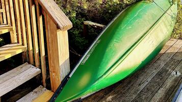A green kayak on a wooden deck.